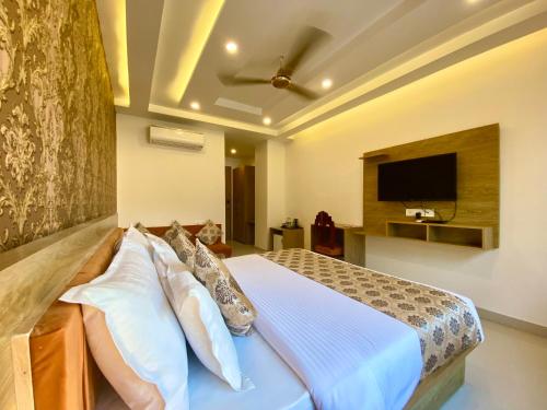 a bedroom with a bed and a flat screen tv at Arogyadham Wellness Retreat in Rishīkesh