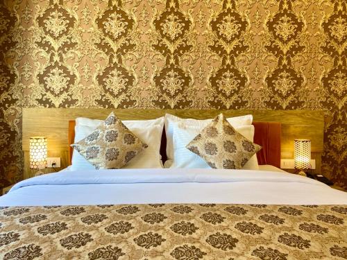 a bedroom with a bed with pillows and a wallpaper at Arogyadham Wellness Retreat in Rishīkesh