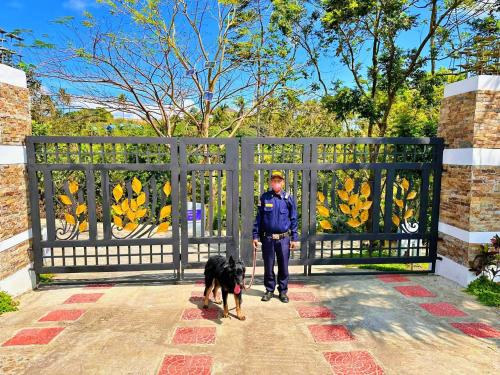 a man with a dog standing next to a gate at Shanti Wellness Sanctuary in Lemery
