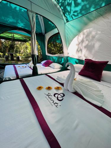 two beds in a tent with a swan on it at Shanti Wellness Sanctuary in Lemery