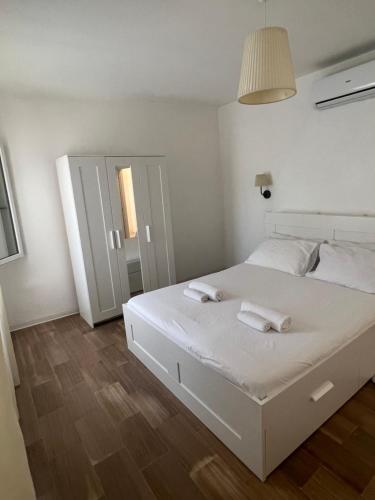 um quarto com uma cama branca com duas toalhas em Center, 15 minutes from Venice, Parking Miranese em Mestre