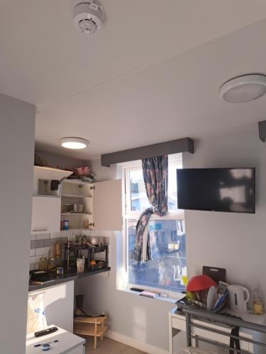 ein Wohnzimmer mit einem Fenster, einem Tisch und einem Schreibtisch in der Unterkunft Mo's Room in London