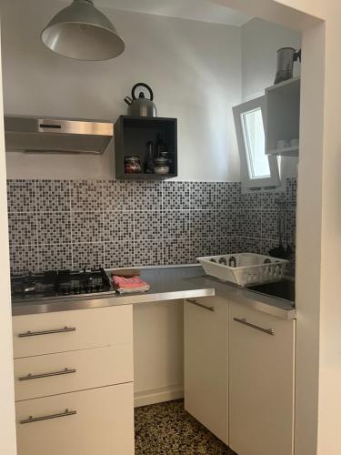 a kitchen with white cabinets and a counter top at Center, 15 minutes from Venice, Parking Miranese in Mestre