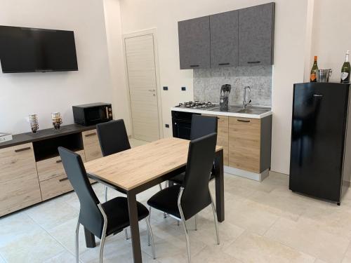 a kitchen with a wooden table and a black refrigerator at B&B Giusy in Sava