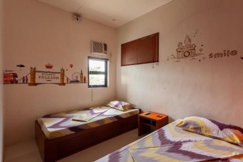 a bedroom with two beds and a small table at TERRA: Grove area, 2 min walk to UPLB Gate in Los Baños