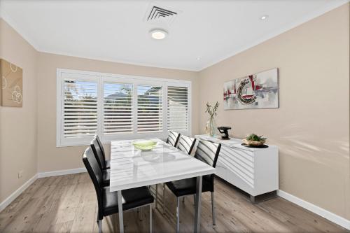 a dining room with a white table and chairs at Shearwater Place in Coffs Harbour