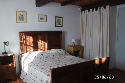 1 dormitorio con 1 cama con cabecero de madera en Mas Grimaud - Gîte- Studio et chambres d'hôtes familiales en Eygalières