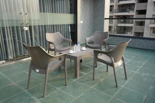 un grupo de sillas y una mesa en el balcón en HOTEL OM INN, en Gandhinagar