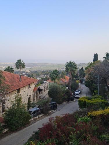 a street in a village with cars parked on the road at על שפת אגם כנרת in Tiberias