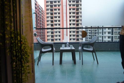 a table and chairs on a balcony with buildings at HOTEL OM INN in Gandhinagar
