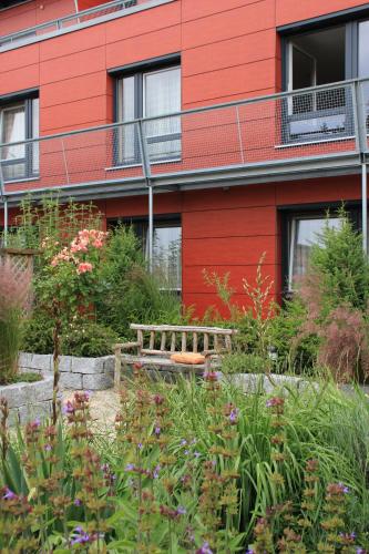 a garden in front of a red building at Hotel Linner in Erding