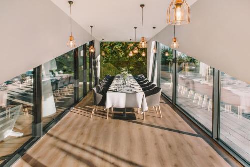 uma sala de jantar com mesa, cadeiras e janelas em Courtyard by Marriott Vilnius City Center em Vilnius