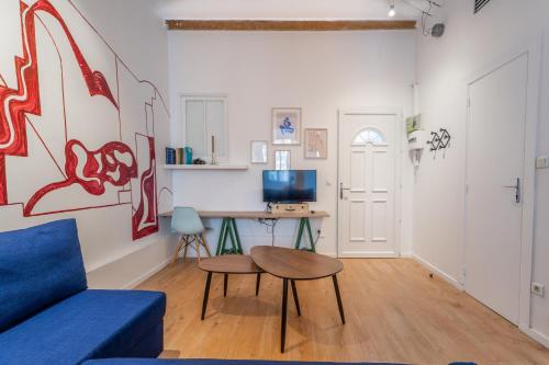 sala de estar con sofá azul y mesa en L'Atelier d'Artiste - refuge bohème et créatif, en Toulon