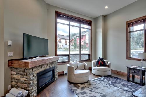 a living room with a fireplace and a flat screen tv at Village Walk #21 By Bear Country in Sun Peaks