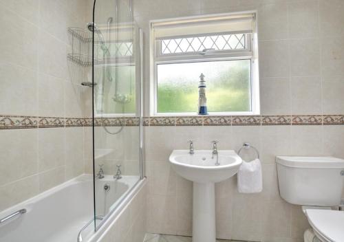 サンダースフットにあるCilrhedynのバスルーム(洗面台、トイレ付)、窓が備わります。