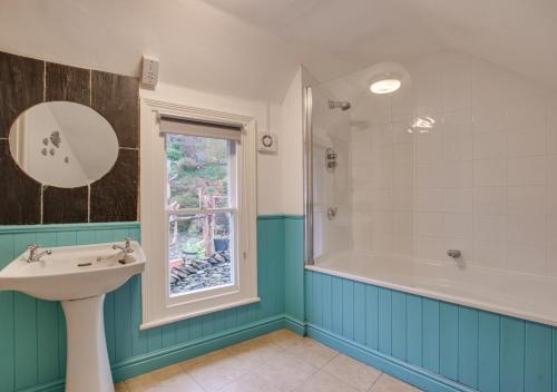 a bathroom with a sink and a tub and a window at Bryn Hyfryd in Penmaenpool