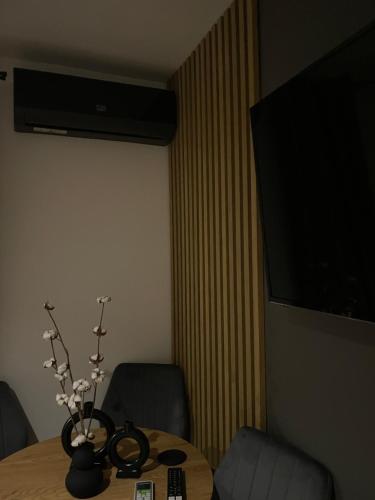 a room with a table with a vase of flowers on it at Modern Cozy Apartment Zalau in Zalău