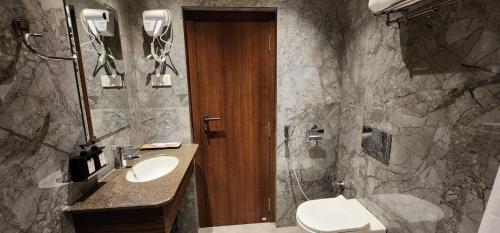 a bathroom with a sink and a toilet and a mirror at Hotel Gorbandh in Udaipur