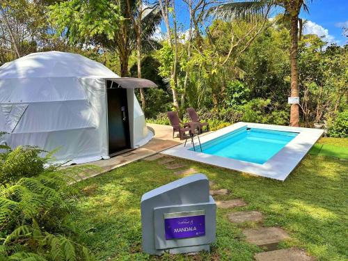 a luxury tent with a swimming pool in a yard at Shanti Wellness Sanctuary in Lemery