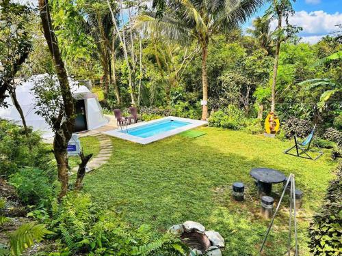 a backyard with a swimming pool in the grass at Shanti Wellness Sanctuary in Lemery