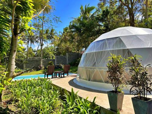 a greenhouse in a garden with a table and chairs at Shanti Wellness Sanctuary in Lemery