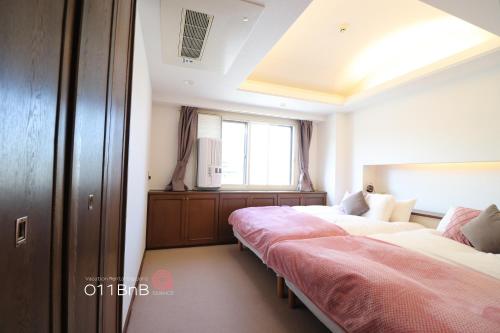 a room with three beds and a window at NK BLD5F Sapporo 3LDK 3BR 1 floor 1 room in Sapporo