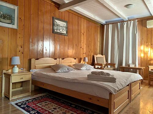 a bedroom with a large bed with wooden walls at Morena Mansion in Murighiol