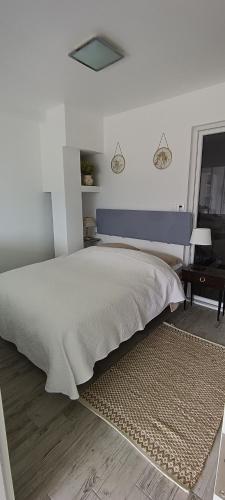 Dormitorio blanco con cama grande y cabecero azul en Studio 2 Cabana de pe Stanca, en Colibiţa