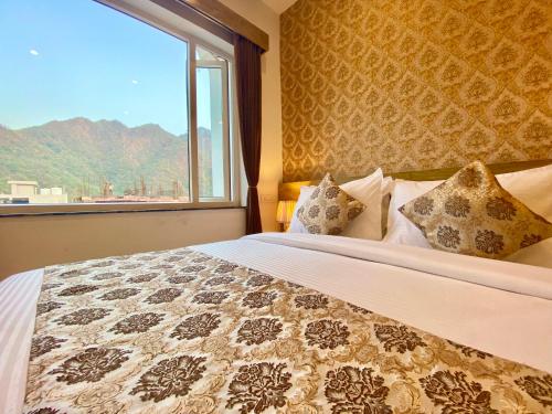 a bedroom with a large bed with a window at Arogyadham Wellness Retreat in Rishīkesh