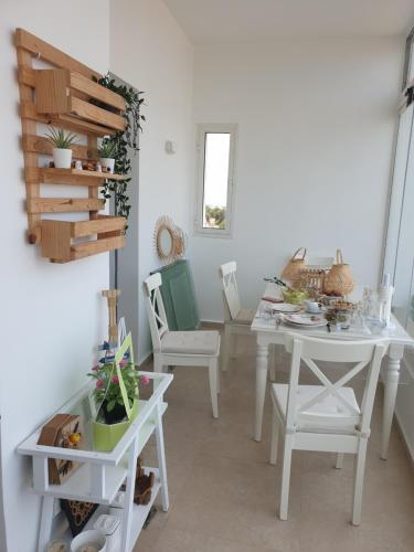 a dining room with white tables and chairs at Luxueux appartement front mer in Sidi Rahal