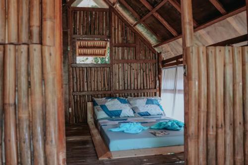ein Bett in einem Bambuszimmer mit Bettblende in der Unterkunft Mayana By Blue Space in Banlot