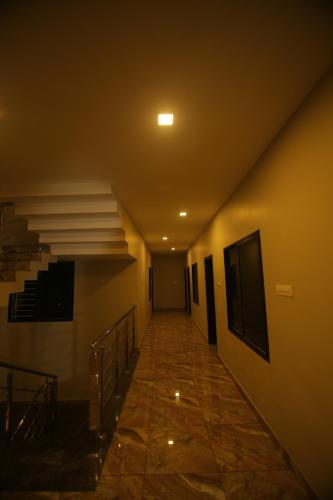 un corridoio di un edificio con scala e luce di ZAHIR RESIDENCY a Kondotti