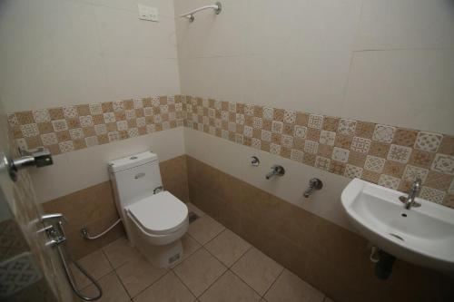 a bathroom with a toilet and a sink at ZAHIR RESIDENCY in Kondotti