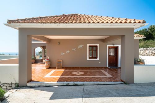 a small house with a large patio at Kumusha Villa near Fiscardo in Mánganos