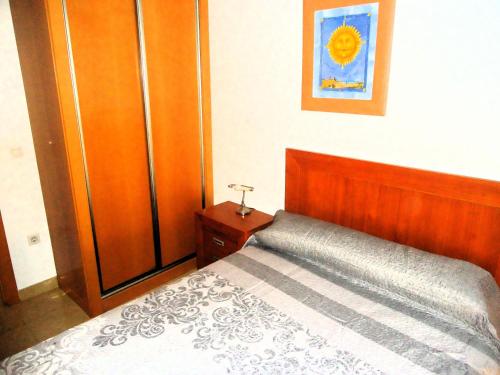 a bedroom with a bed and a wooden closet at Mediterraneo LEK in Peñíscola