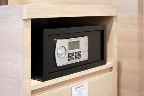 a microwave in a wooden box with a clock in it at Sotetsu Grand Fresa Saigon in Ho Chi Minh City