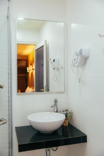 a bathroom with a sink and a mirror at Hotel Sentral Kuantan @ Riverview City Centre in Kuantan