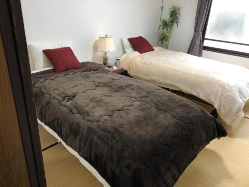 two beds sitting next to each other in a room at Cool-Residence OTARU in Otaru