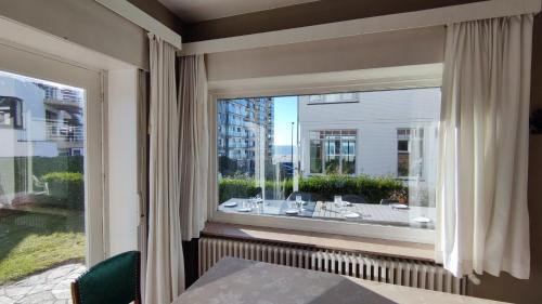 a window with a view of a table and chairs at Les Pinsons - Familievilla met strandzicht én tuin in Knokke-Heist