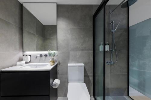 a bathroom with a shower and a toilet and a sink at Veriu Collingwood in Melbourne