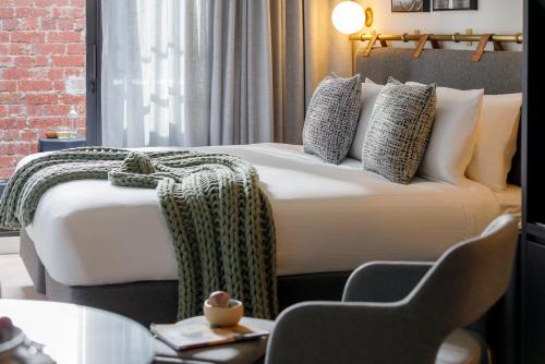 a hotel room with a large bed and a table and chairs at Veriu Collingwood in Melbourne