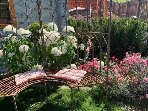 un banco en medio de un jardín con flores en Appartementhaus Alma, en Haus im Ennstal