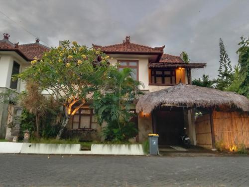 a house with a tree and a building at KUTA - 4BR Villa with Private XL Pool in Kuta