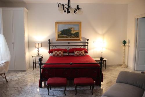 a bedroom with a large red bed with red pillows at Il Giardino della Scuncerta in Lecce