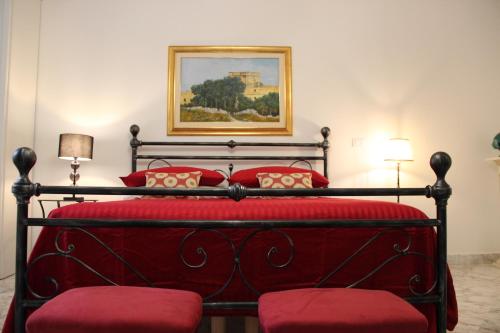 a bedroom with a red bed with two red pillows at Il Giardino della Scuncerta in Lecce