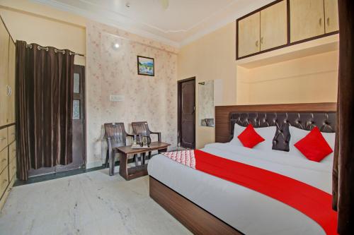 Habitación de hotel con cama con almohadas rojas en Flagship Hotel Elite Inn, en Jaipur