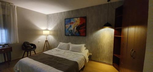 - une chambre avec un lit et une peinture murale dans l'établissement BLUE SKY, à Bet HaKerem
