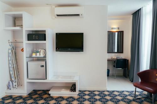 Hotel Sentral Kuantan @ Riverview City Centre في كُوانتان: غرفة معيشة مع تلفزيون بشاشة مسطحة على جدار