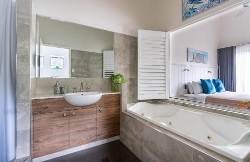 a bathroom with a tub and a sink and a bed at At Forest Stay in Margaret River Town