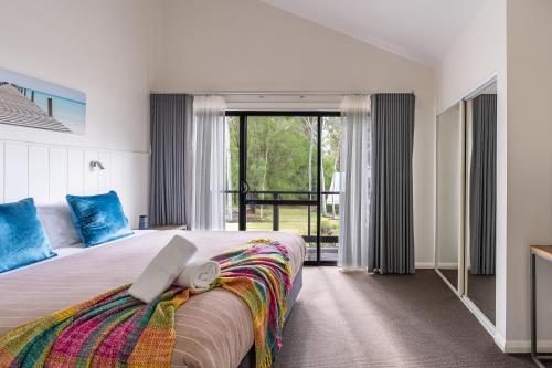 een slaapkamer met een groot bed en een groot raam bij At Forest Stay in Margaret River Town